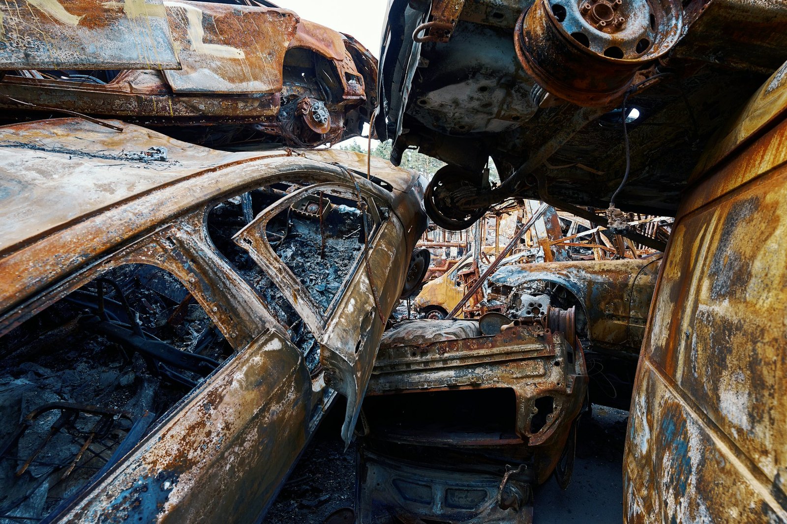 Charred cars mounted on each other in scrapyard in Ukraine